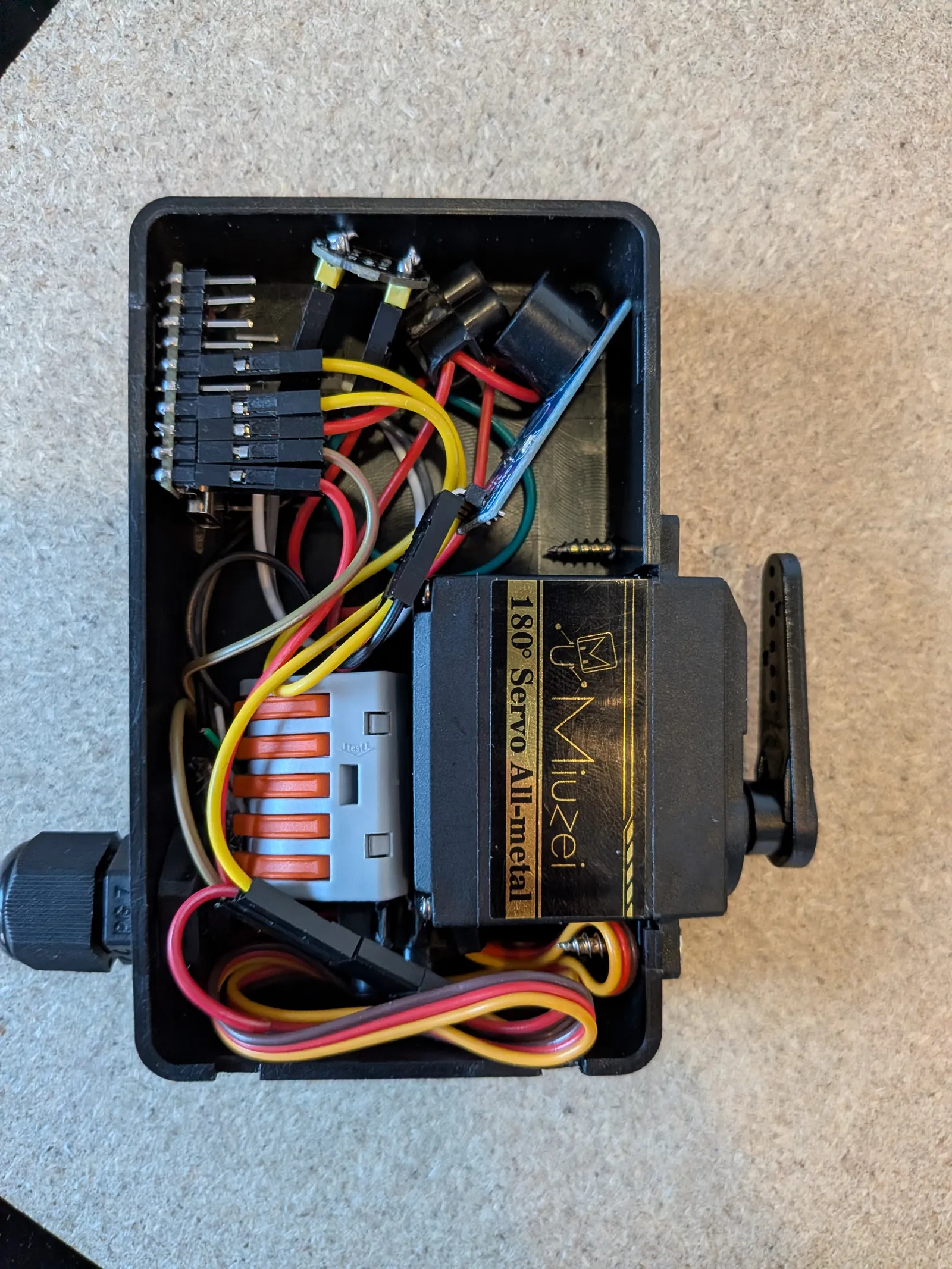 Boîtier final ouvert avec l'ESP32-C6 mini et le servo installés